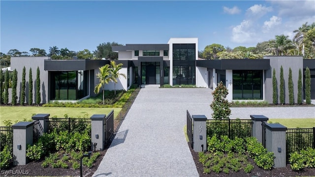 view of front of home with a fenced front yard, a front yard, driveway, and stucco siding