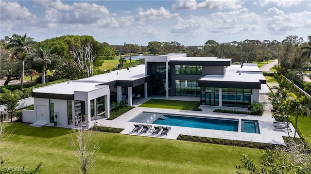 rear view of property featuring a patio, fence, a lawn, and an outdoor pool