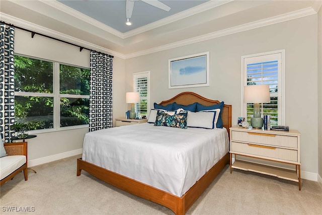 carpeted bedroom featuring ceiling fan, ornamental molding, and a tray ceiling