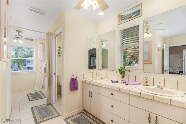 bathroom with toilet, tile patterned floors, and vanity