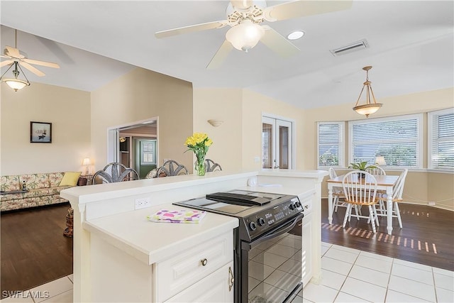 kitchen with light tile patterned floors, ceiling fan, white cabinets, decorative light fixtures, and black / electric stove