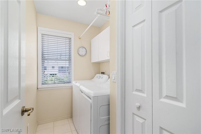 washroom with cabinets, washer and clothes dryer, and light tile patterned floors