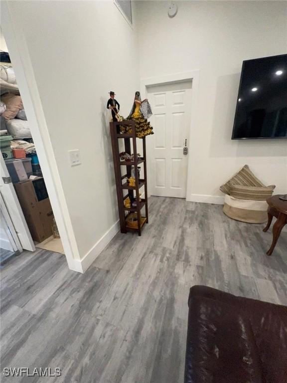 foyer with a towering ceiling, baseboards, and wood finished floors