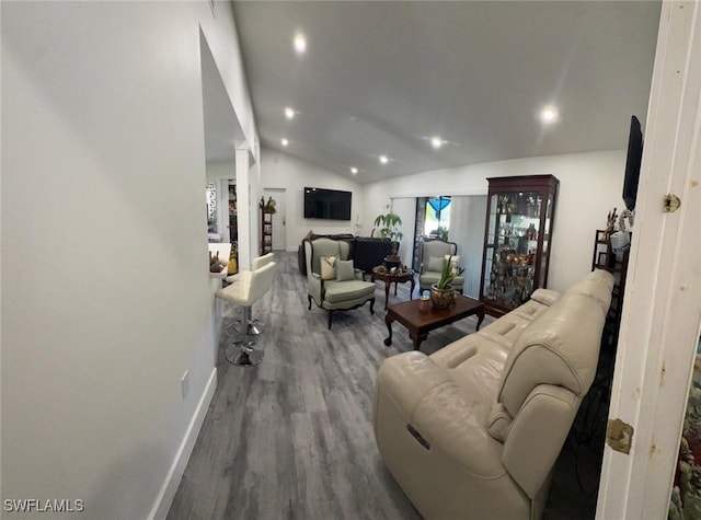 living area featuring baseboards, vaulted ceiling, wood finished floors, and recessed lighting