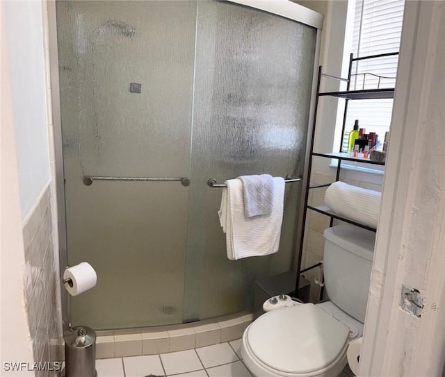 full bathroom featuring a shower stall, toilet, and tile patterned floors