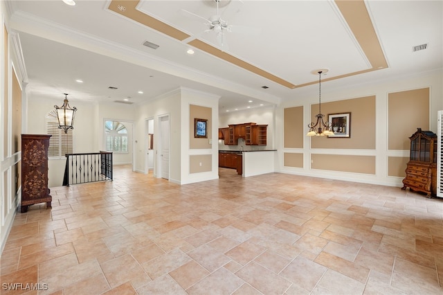 living room with ceiling fan with notable chandelier, ornamental molding, and a raised ceiling