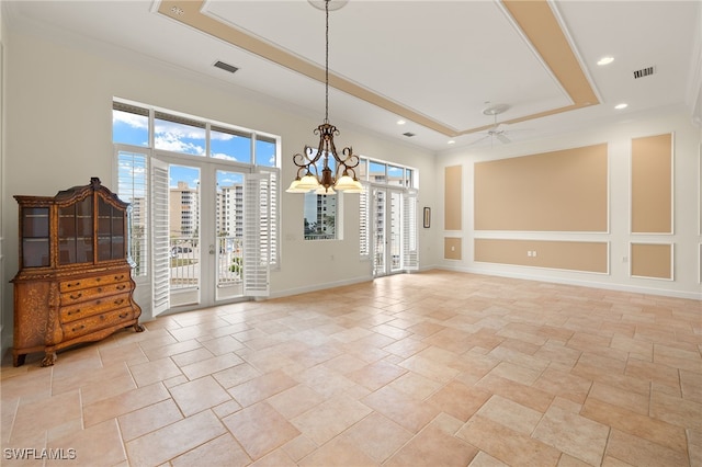 empty room featuring crown molding, ceiling fan with notable chandelier, and a tray ceiling