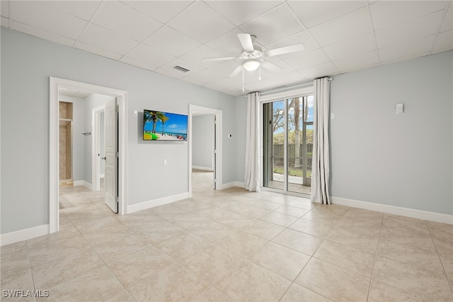 spare room with ceiling fan and a drop ceiling