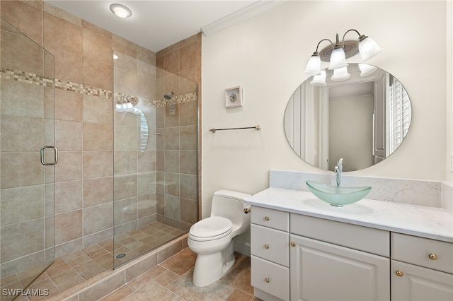 bathroom with crown molding, vanity, toilet, and a shower with shower door