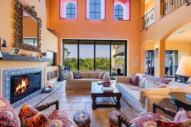 living room with a fireplace and a high ceiling