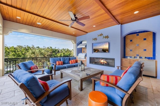 view of patio featuring an outdoor living space with a fireplace, area for grilling, and ceiling fan