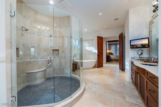 full bath featuring a stall shower, a soaking tub, ensuite bathroom, vanity, and recessed lighting