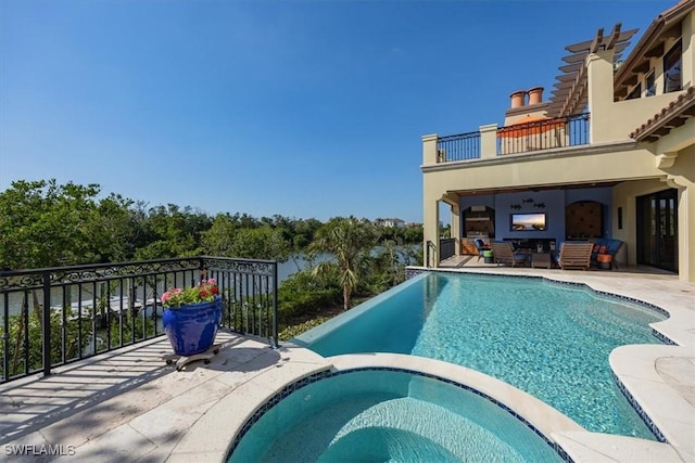 view of swimming pool featuring a pool with connected hot tub and a patio