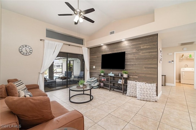 tiled living room featuring washer / dryer, wooden walls, ceiling fan, and lofted ceiling