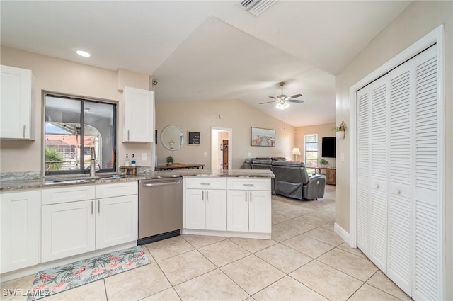 kitchen with stainless steel dishwasher, vaulted ceiling, ceiling fan, sink, and white cabinetry