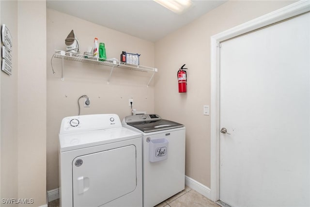 clothes washing area featuring separate washer and dryer and light tile patterned floors