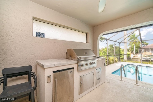 view of patio / terrace with a lanai, area for grilling, ceiling fan, and an outdoor kitchen