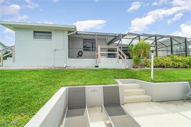 back of house with a yard and a lanai