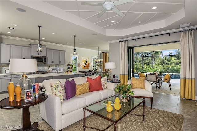 tiled living room featuring a raised ceiling, ceiling fan, and crown molding