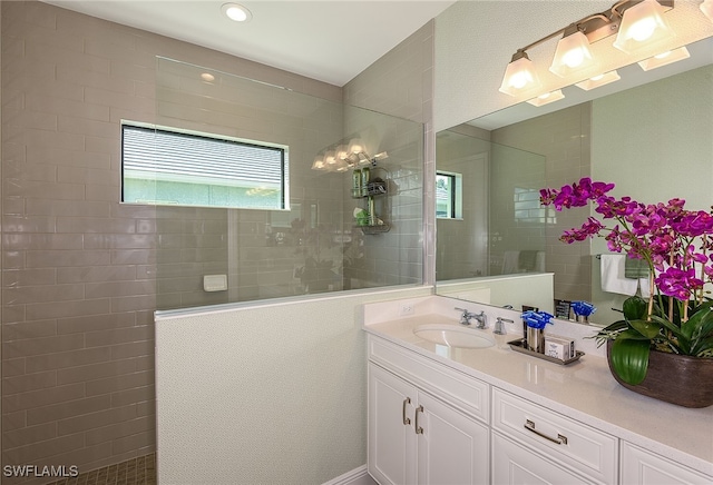 bathroom featuring a tile shower and vanity