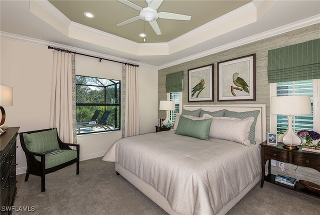 bedroom with a tray ceiling, ceiling fan, carpet flooring, and crown molding