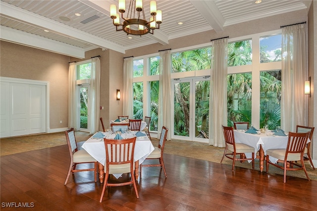 sunroom / solarium with beam ceiling and an inviting chandelier