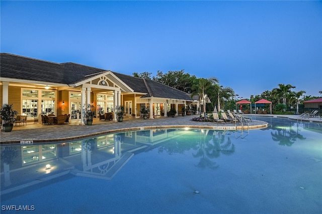 pool at dusk featuring a patio area