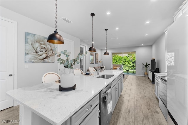 kitchen with stainless steel appliances, a spacious island, sink, white cabinetry, and hanging light fixtures