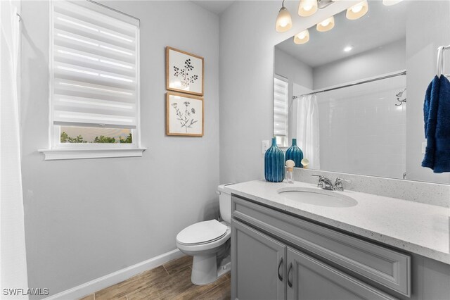 bathroom with a shower with shower curtain, vanity, and toilet