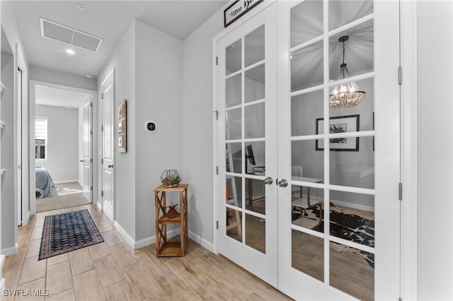 hall featuring a chandelier and french doors