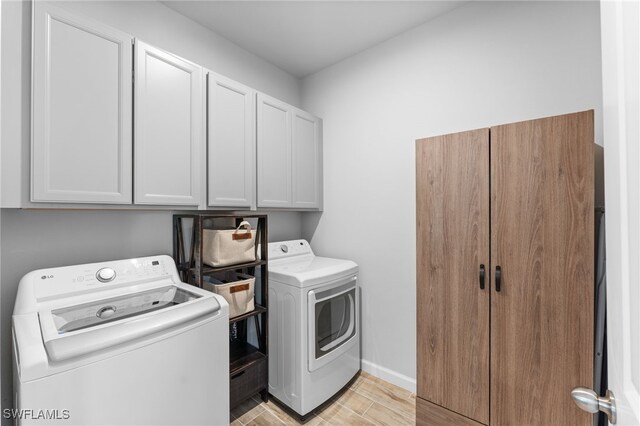 washroom featuring cabinets and washer and dryer