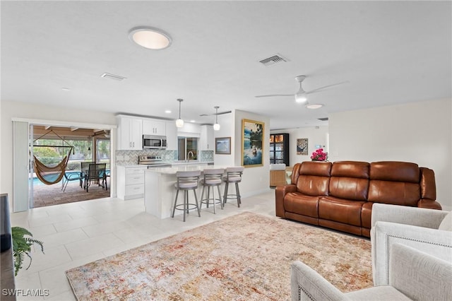 tiled living room with ceiling fan