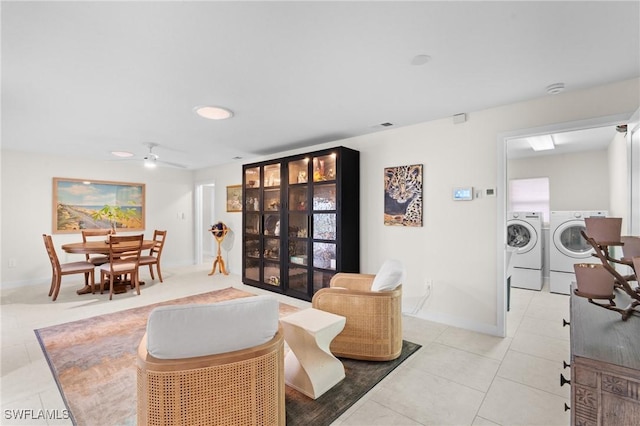 living room featuring ceiling fan, light tile patterned floors, and washer and clothes dryer