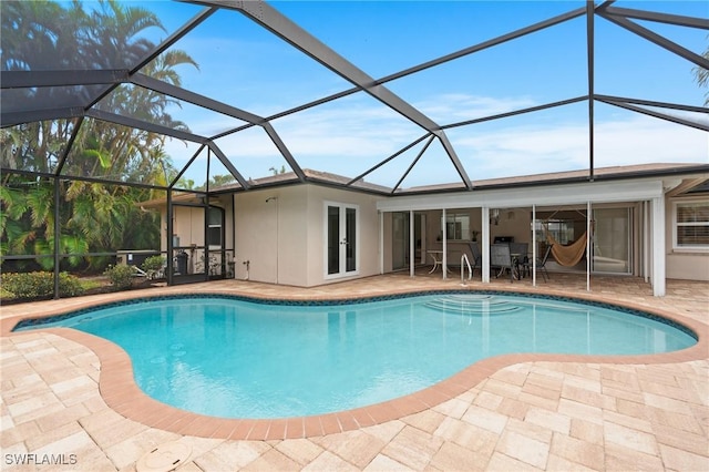 view of pool with a patio and glass enclosure