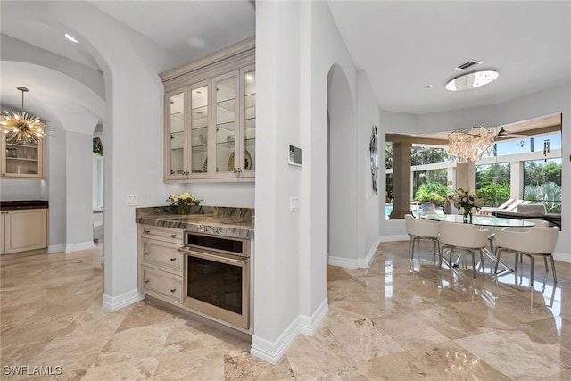 kitchen with cream cabinets, a notable chandelier, and oven