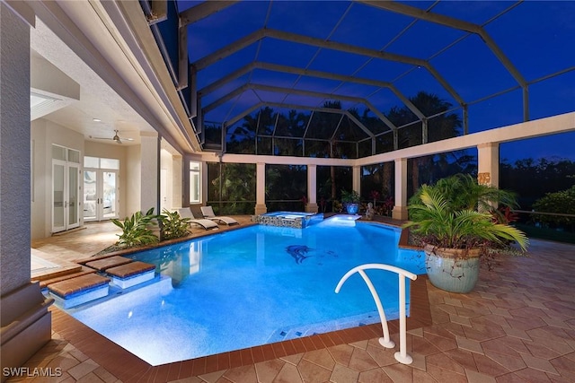 view of swimming pool featuring a patio, glass enclosure, and an in ground hot tub