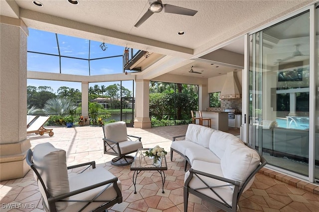 sunroom / solarium featuring ceiling fan and a water view