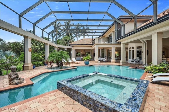 view of pool with glass enclosure, an in ground hot tub, and a patio area