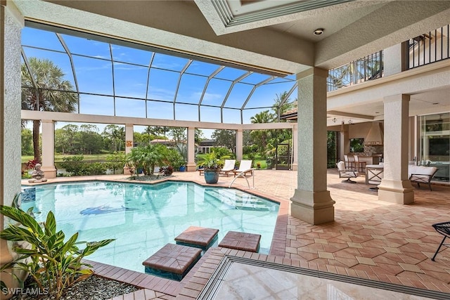 view of pool featuring a lanai, exterior kitchen, and a patio area