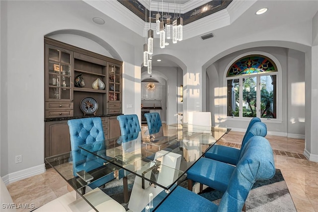 dining area with a chandelier, ornamental molding, and a tray ceiling