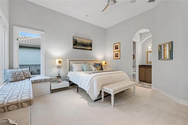 carpeted bedroom featuring ensuite bath, ceiling fan, and vaulted ceiling