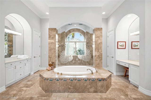 bathroom with tiled tub and vanity