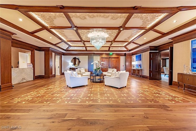 unfurnished living room featuring coffered ceiling, ornamental molding, hardwood / wood-style floors, and a notable chandelier