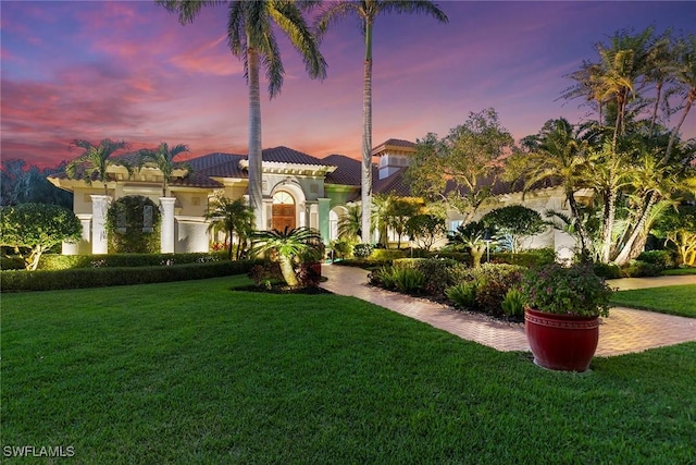 mediterranean / spanish home featuring a lawn