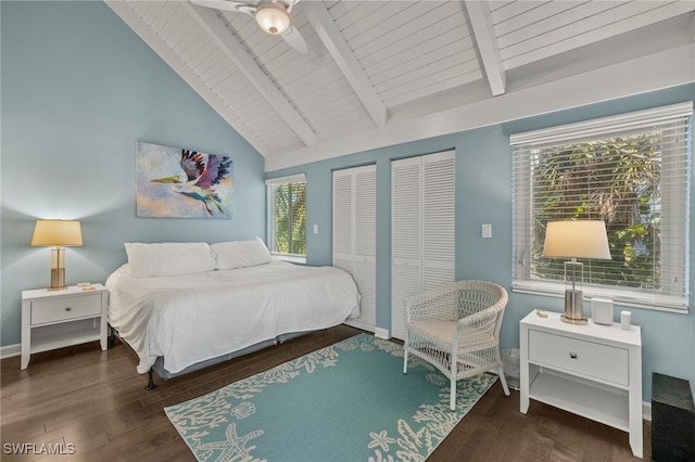 bedroom featuring lofted ceiling with beams, dark hardwood / wood-style floors, ceiling fan, and multiple closets