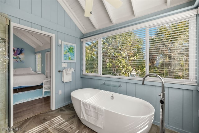 bathroom featuring a bath, lofted ceiling with beams, parquet floors, and ceiling fan