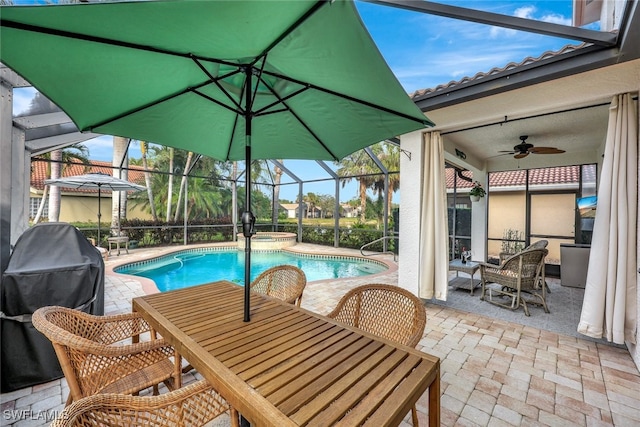 view of swimming pool featuring ceiling fan, a lanai, an in ground hot tub, and a patio area