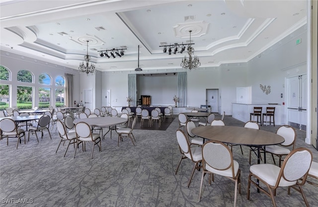 dining space with a high ceiling, a tray ceiling, and crown molding