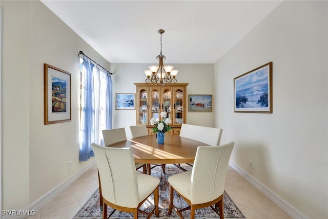 tiled dining room with a chandelier