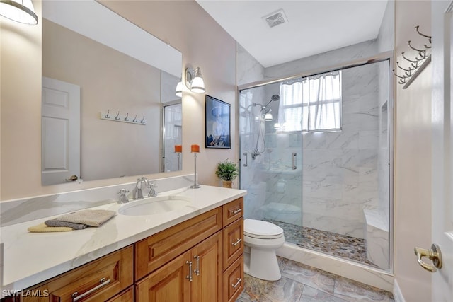 bathroom featuring toilet, vanity, and walk in shower